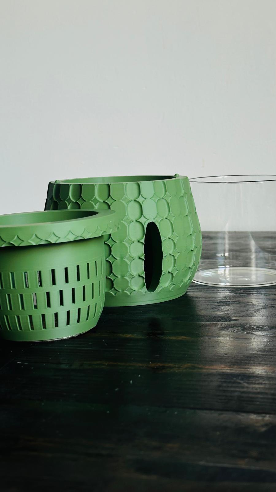 Tirla self watering plant pot by Solvi3D in Olive green, showing inner medium basket and glass liner.